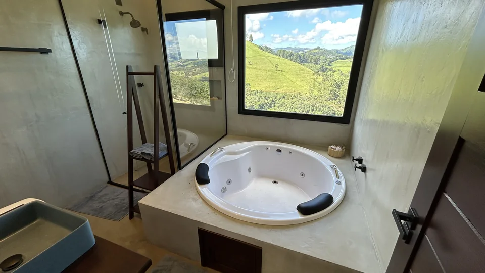 Ofurô com hidromassagem e janela panorâmica para os vales da serra