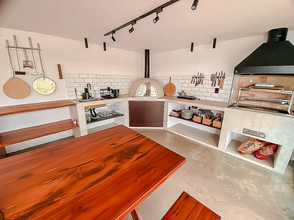 Área gourmet com forno a lenha e churrasqueira diante da vista