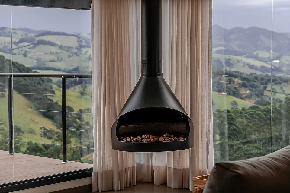 Living integrado com lareira suspensa e vista panorâmica para os vales