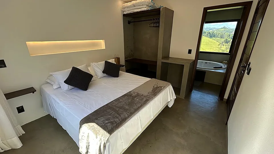 Suíte com cama ampla e janelas voltadas para os vales
